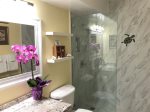 Glass enclosed shower bathroom shared between queen and twin bedrooms
